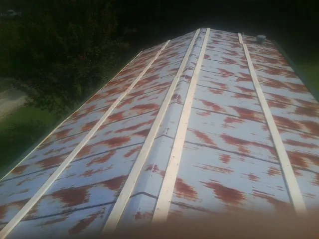 Rusted metal roof panels with new wood purlins before replacement — Storm Damage Roof Repair in Alcalde by Roofing Brothers